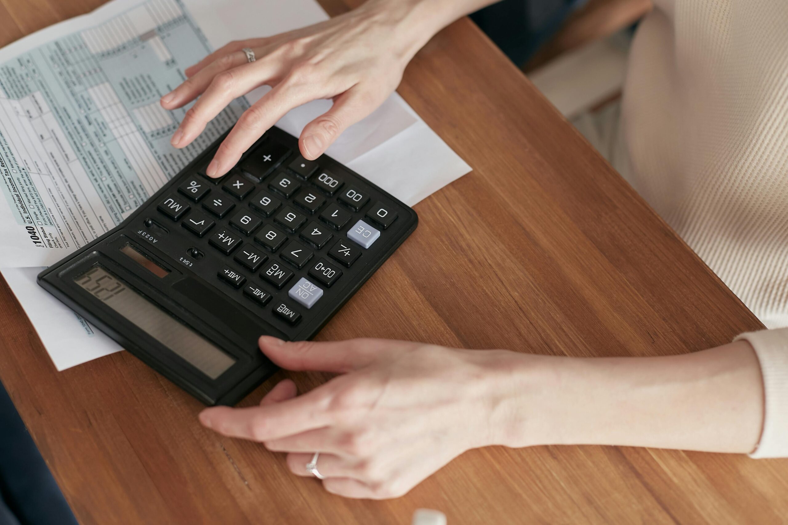 Person using a calculator to pay bills.